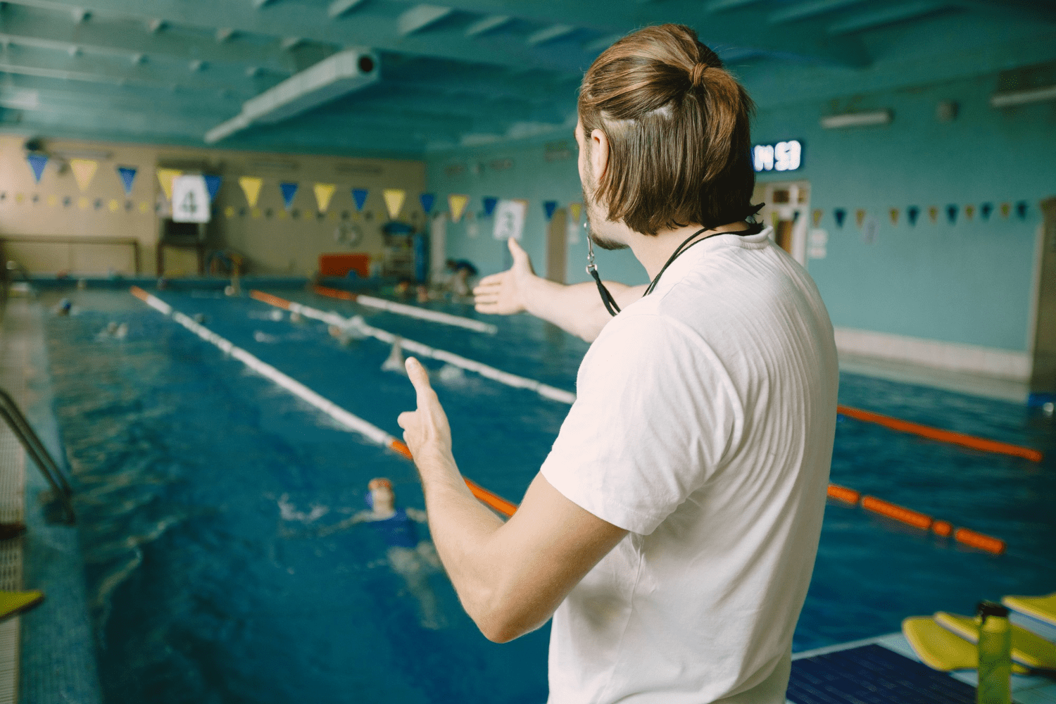 male-swimming-coach-standing-by-swimming-pool-he-is-showing-staight-hand-correct-student-swimming-technique-professional